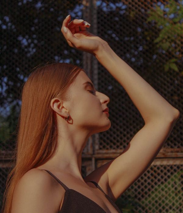 A person in a calm, focused pose in a minimalist studio.